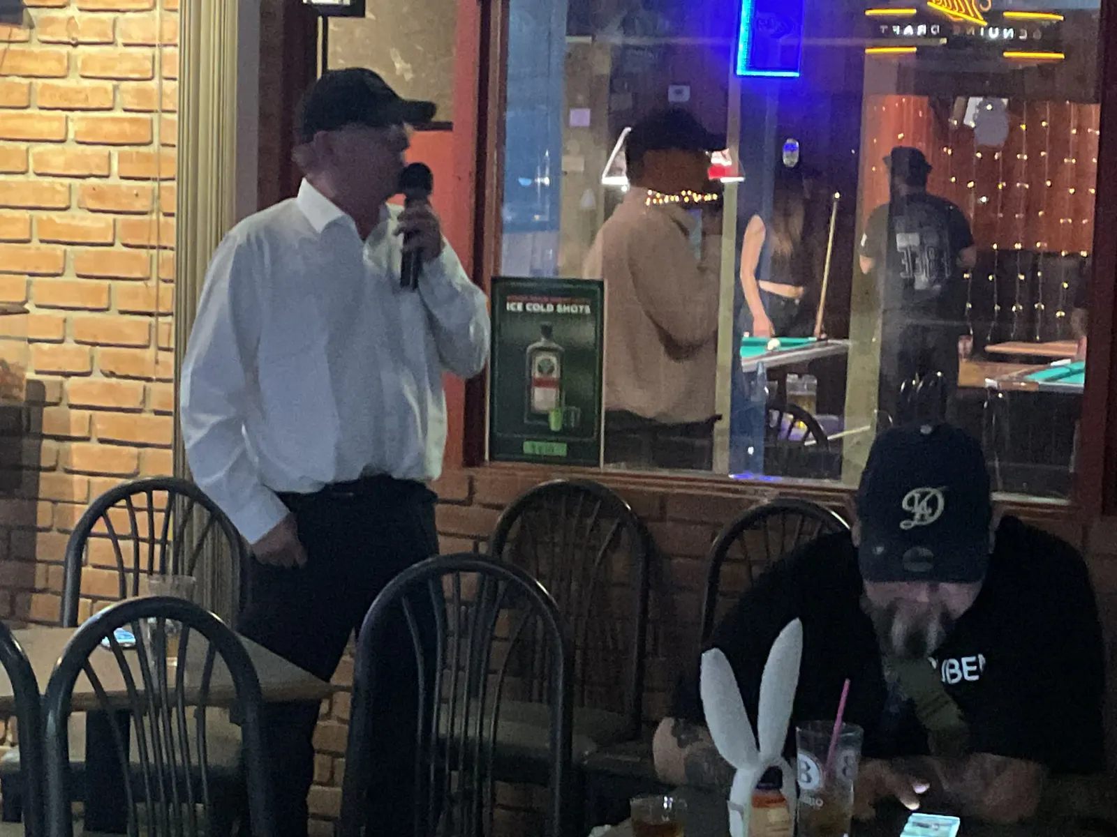 Customer singing karaoke near the pool tables