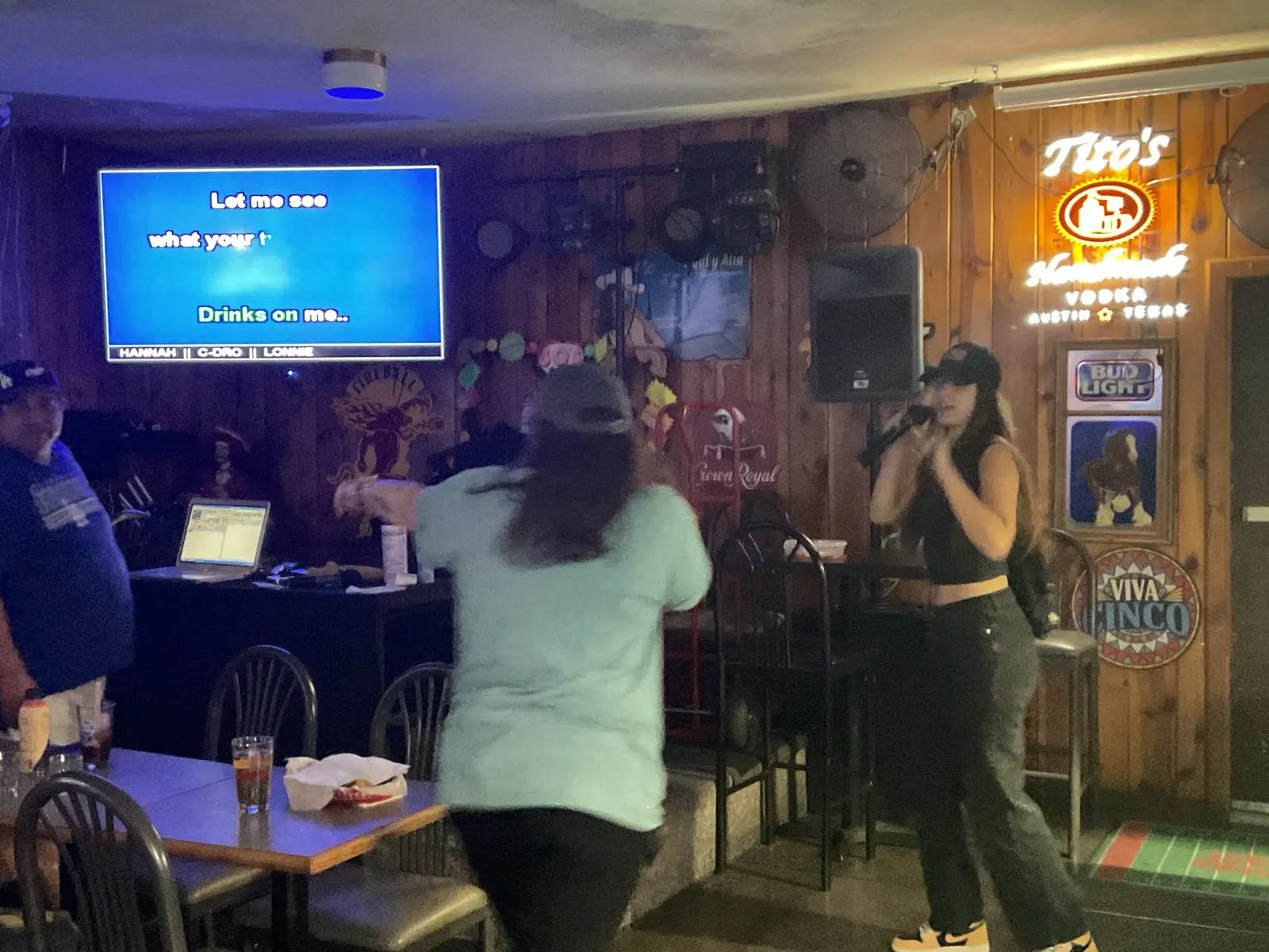 Singer performing karaoke with the song screen behind them