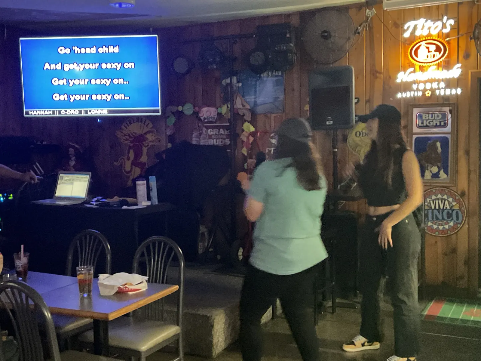 Two friends enjoying karaoke near the bar