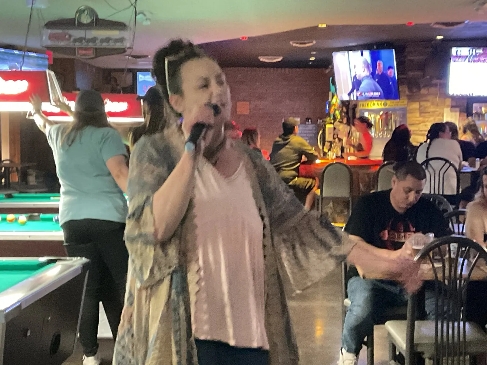Woman singing karaoke at the Wooden Nickel bar